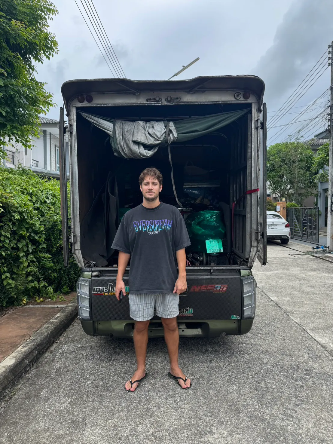 Customer standing at the open back of a BFR truck loaded with motorcycles wrapped in protective covers